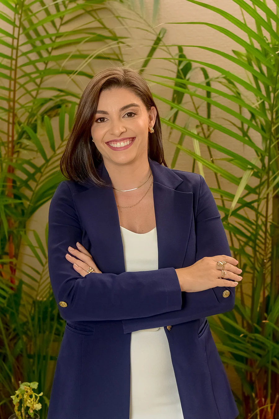 Dra. Fernanda Borba em retrato com blazer azul diante de plantas